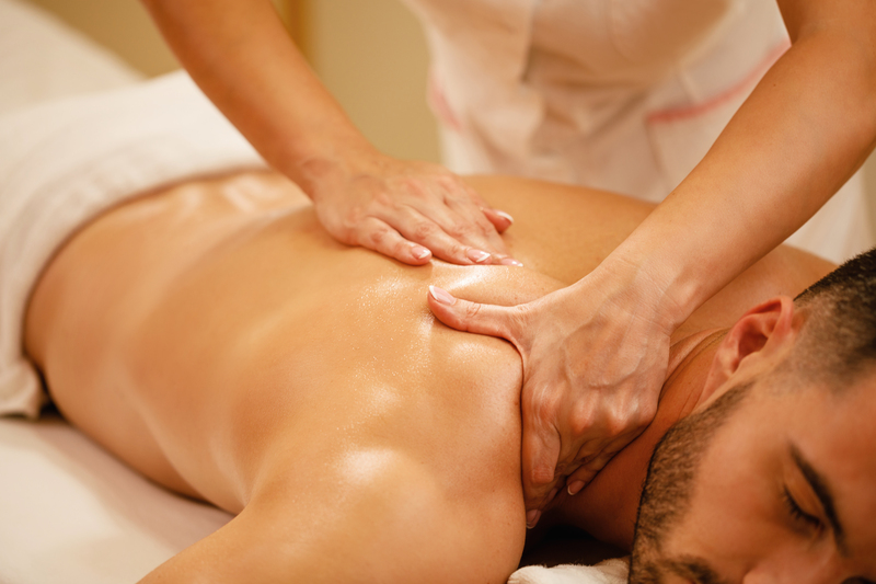 Relaxed man enjoying in back massage at health spa.